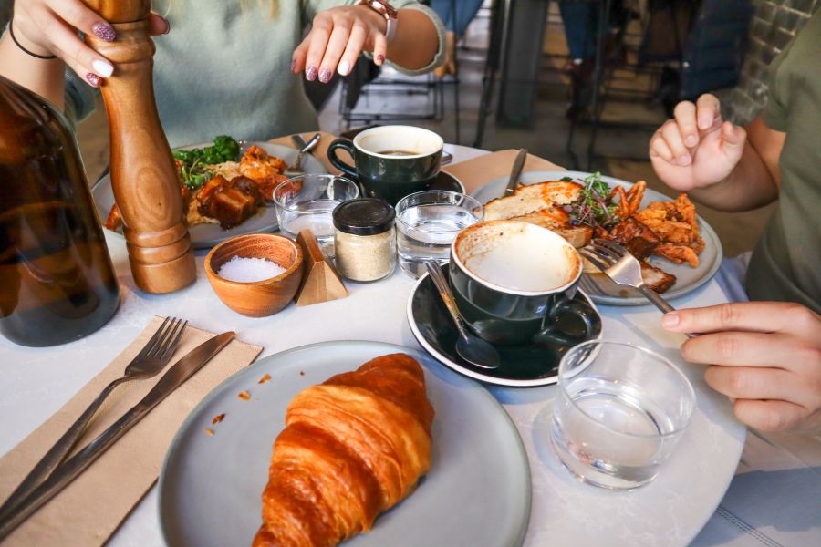 dos personas tomando un desayuno en una cafetería